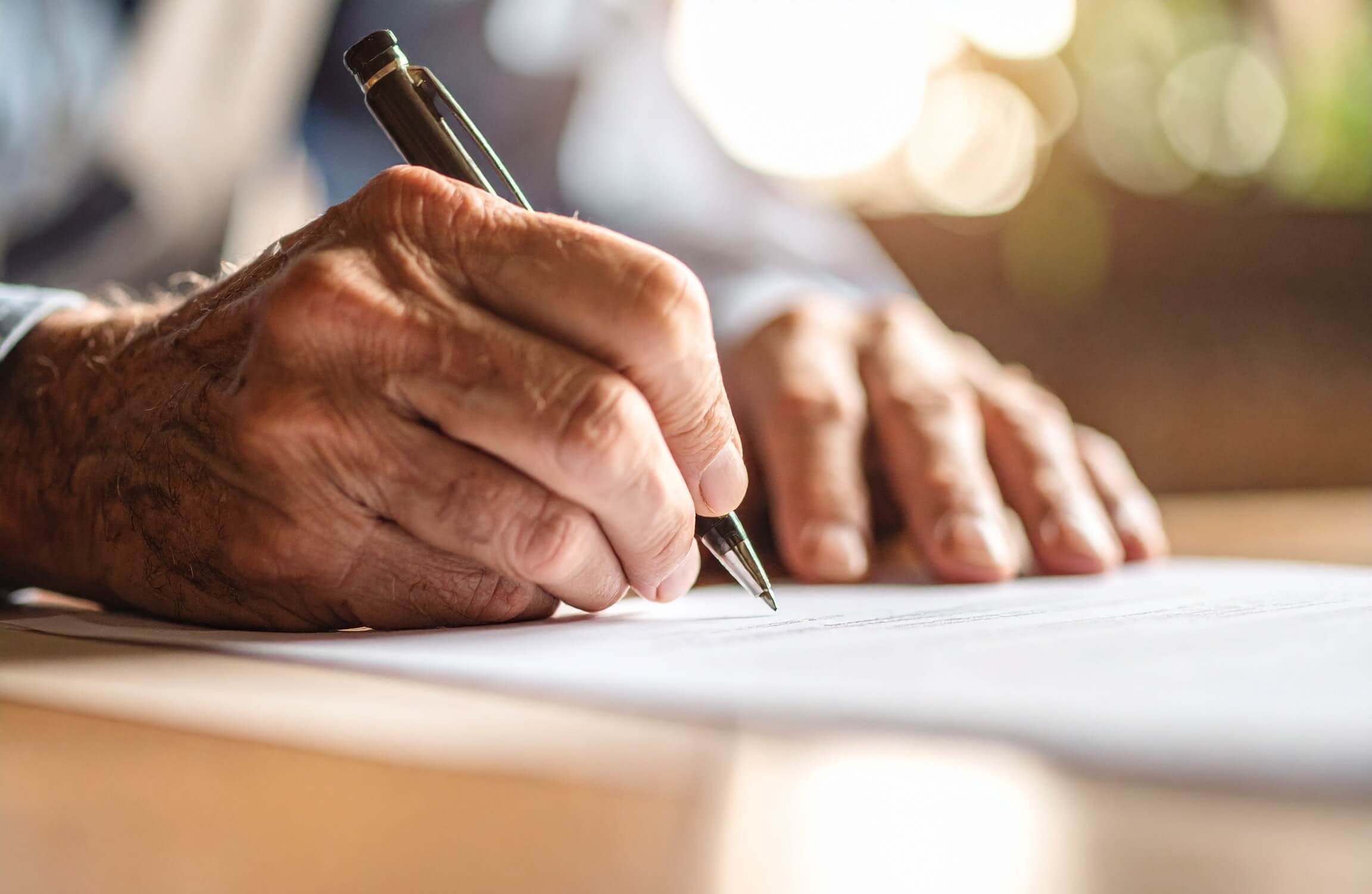 old hand signing a contract